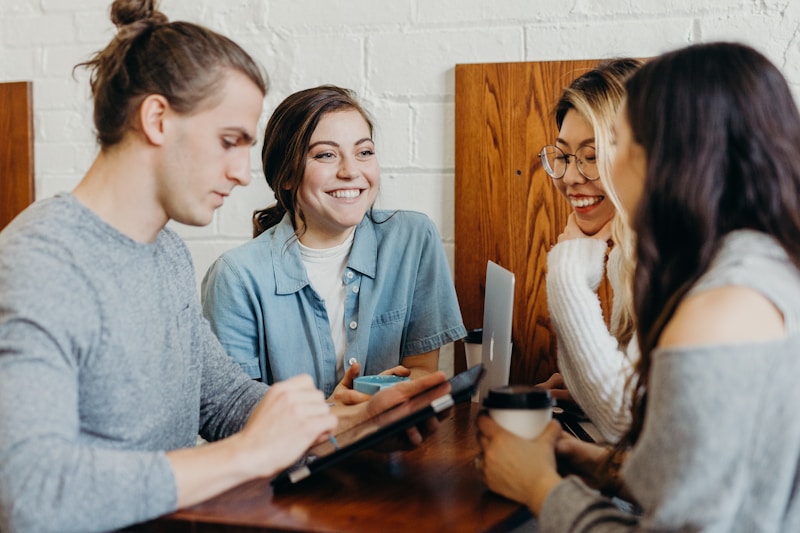 Group of friends with laptops and devices at a coffee shop